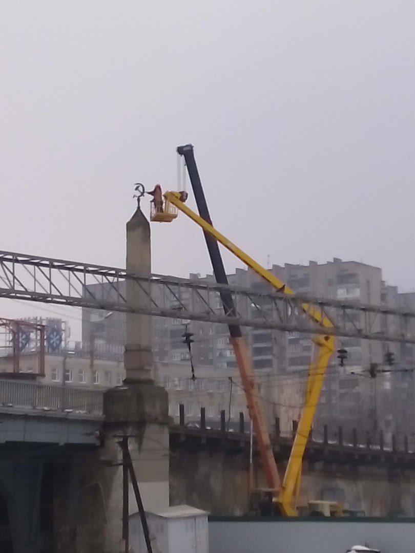 На мосту около завода Малышева срывают с колонн коммунистические символы. ВИДЕО